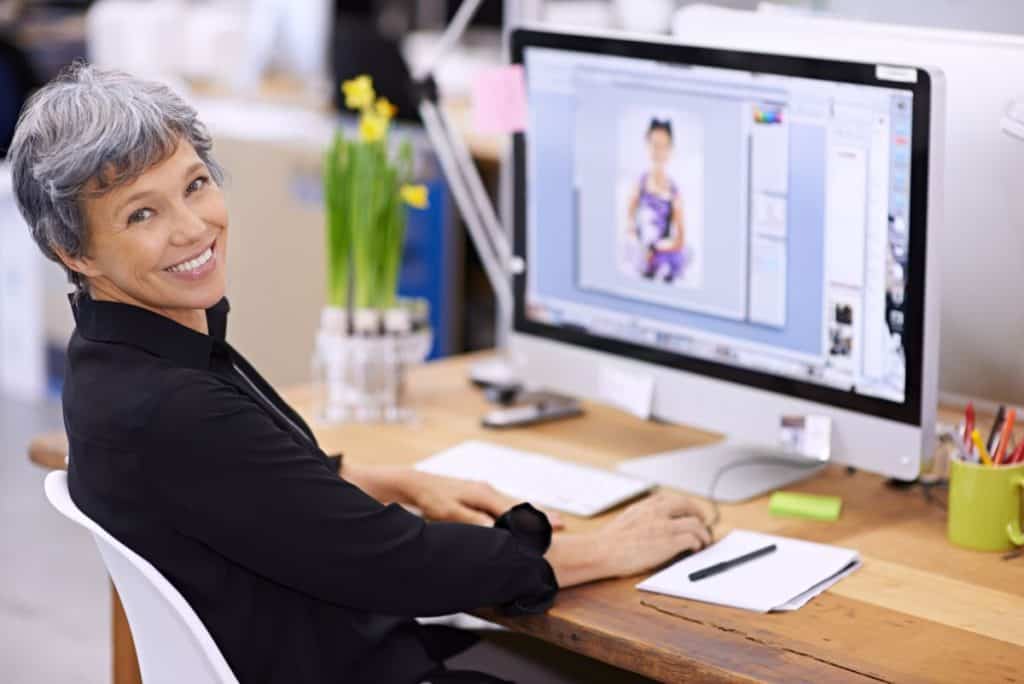Creative woman working on graphic design at computer in office.