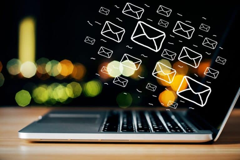 Digital email marketing illustration with floating envelopes over a laptop screen at night, representing online communication and email campaigns.