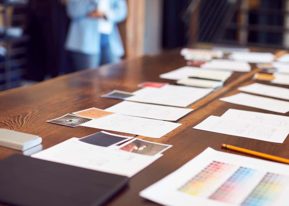 Creative workspace with sketches, color palettes, and design plans for website management by Sandra Lee Creative.